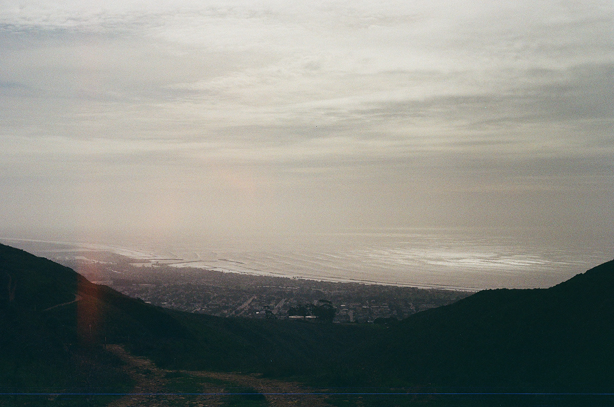Hazy dusk view over a coastal town seen from a mountain vista